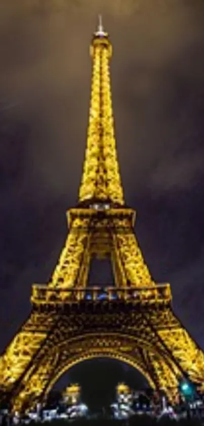 Glowing Eiffel Tower at night under a moody sky.