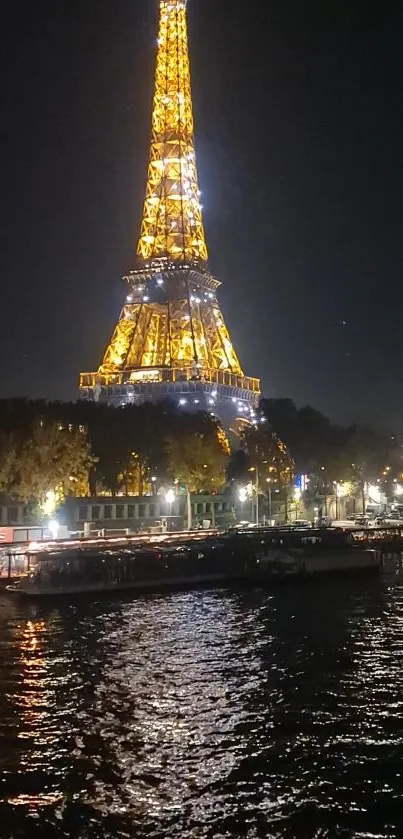 Eiffel Tower illuminated at night over river with city lights.