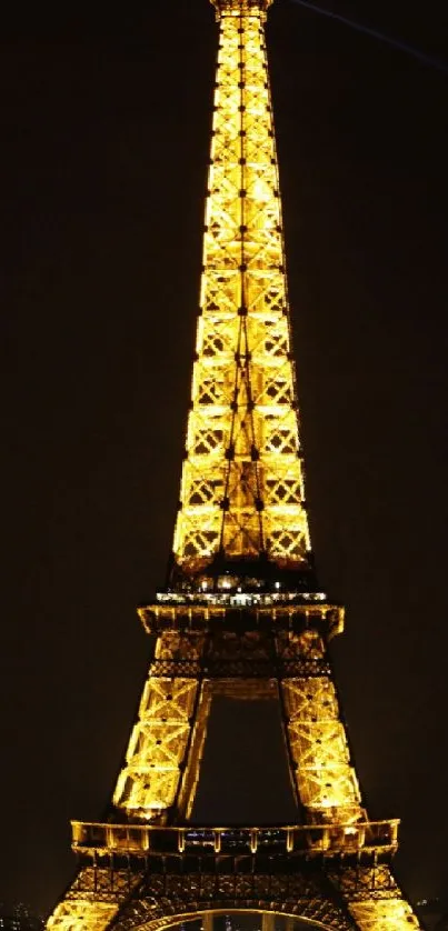 Eiffel Tower illuminated at night in Paris, showcasing a golden glow.