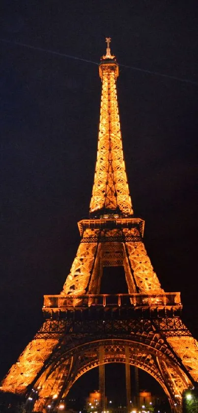 Eiffel Tower glowing at night, beautifully illuminated in Paris.