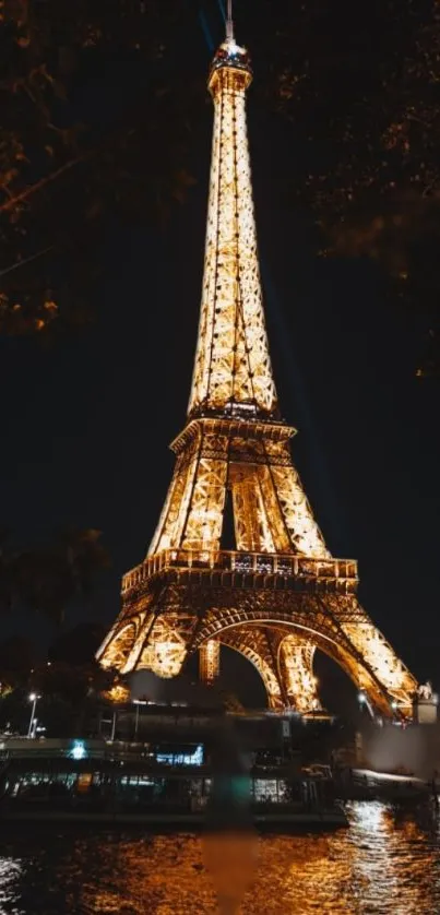 Eiffel Tower glowing at night in Paris, set against a dark sky.