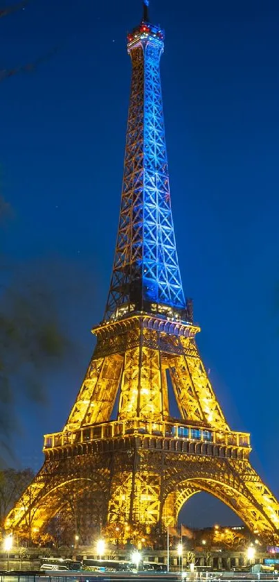 Eiffel Tower illuminated at night with vibrant blue sky.