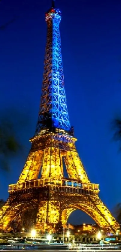 Illuminated Eiffel Tower at night with deep blue sky and reflections.