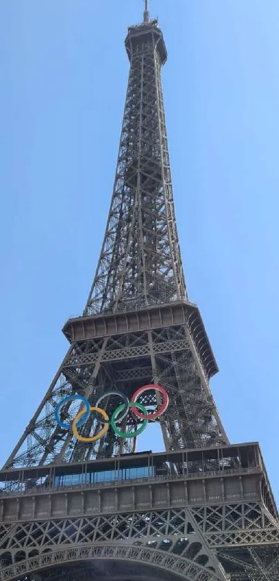 Eiffel Tower with Olympic rings against clear blue sky.