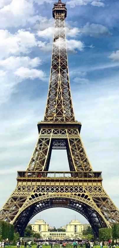 Eiffel Tower against a blue sky with green gardens below.