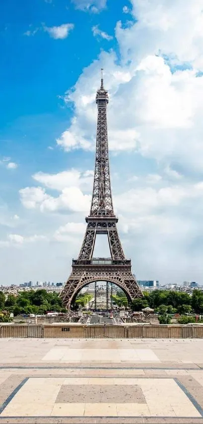 Stunning view of the Eiffel Tower with a bright blue sky and cloud backdrop.