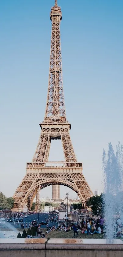 Eiffel Tower with blue sky and fountains in foreground.