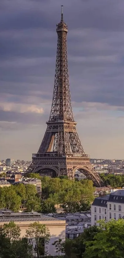 Eiffel Tower with dramatic sky and lush greenery in Paris.