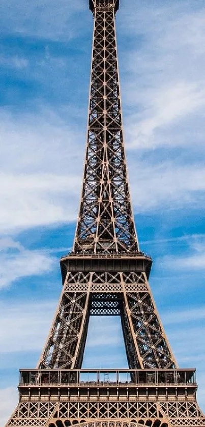 Eiffel Tower against a bright blue sky with scattered clouds.