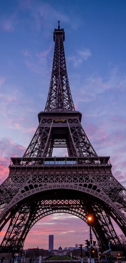 Eiffel Tower at sunset with vibrant blue sky and pink clouds.