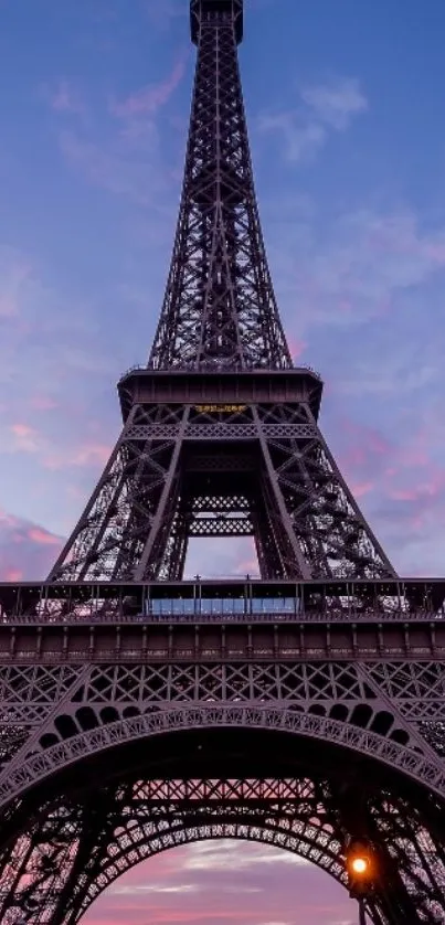 Eiffel Tower at sunset with purple sky and cityscape.