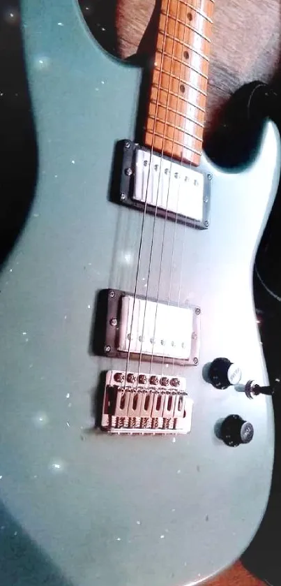 Close-up of an electric guitar with a teal body and wooden neck.