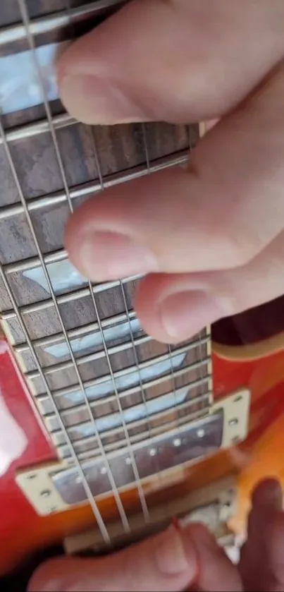 Close-up of hand playing an electric guitar.