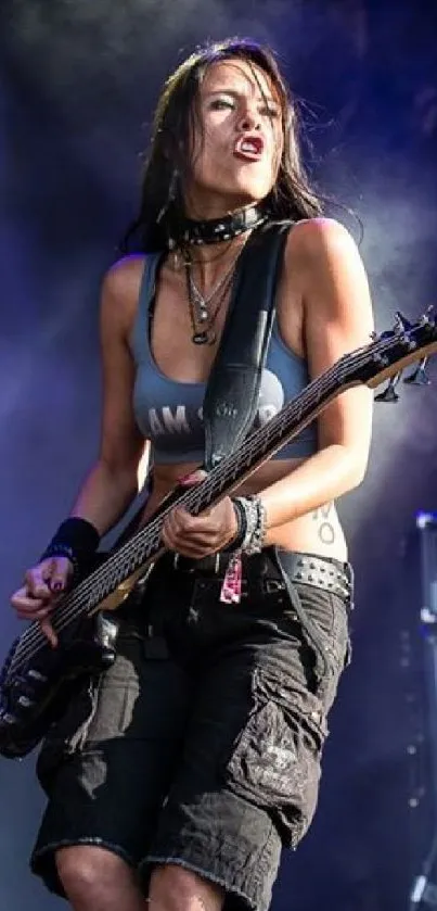 Woman playing electric guitar on stage with dramatic lighting.