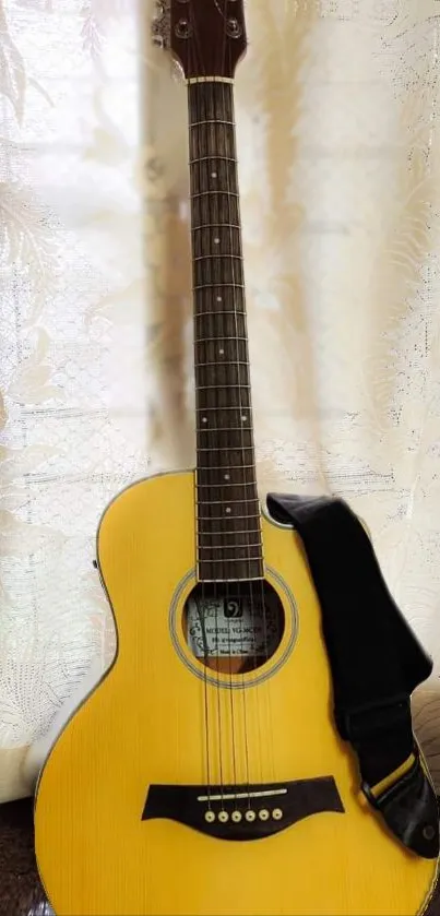 Elegant acoustic guitar with golden hues against a light patterned curtain.