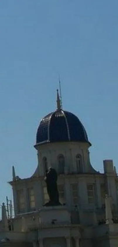 Silhouette of a dome building under a clear blue sky.