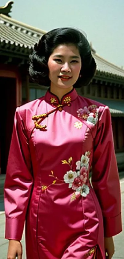 Woman in traditional Asian pink dress with floral embroidery in street background.