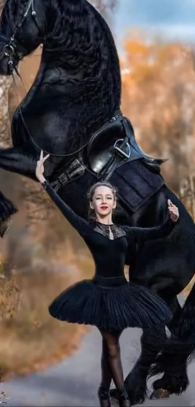 Ballerina in black posing with a rearing horse against an autumn backdrop.