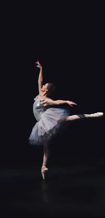 Graceful ballerina in elegant pose on dark background.