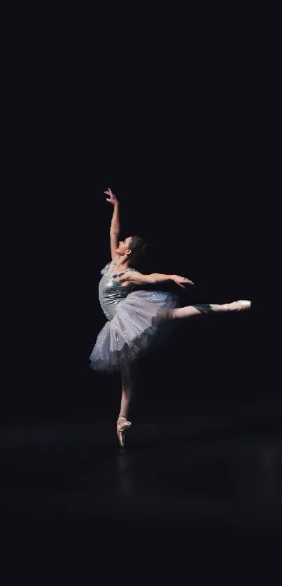 Graceful ballerina striking a pose in a dark elegant setting, perfect for wallpaper.