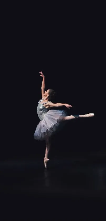 Ballerina performing on a dark stage, displaying elegance and grace.