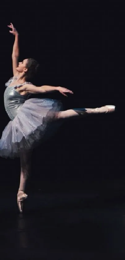 Graceful ballet dancer on a dark stage background.