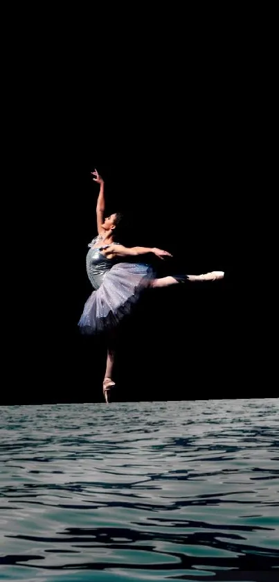 Ballet dancer poised gracefully on a surreal water stage against a dark backdrop.