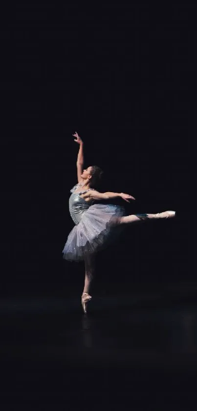 Elegant ballet dancer posing on a dark stage, perfect mobile wallpaper.