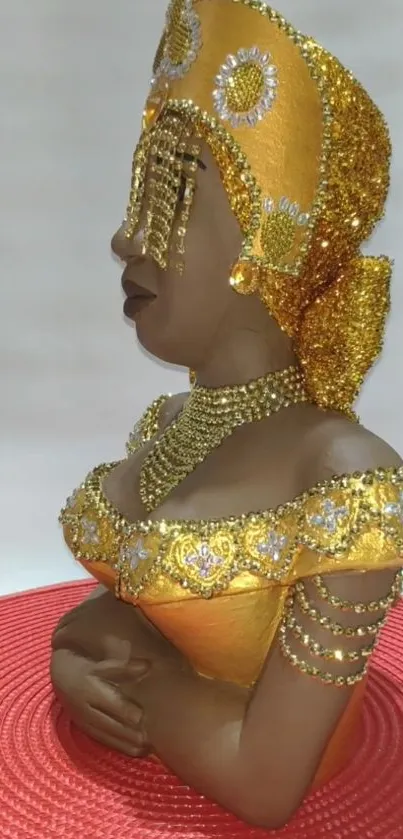 Bejeweled golden sculpture on red base.