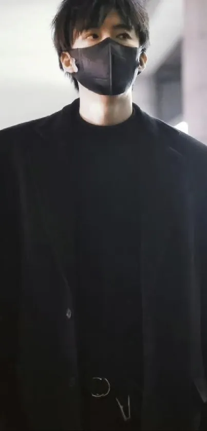 Individual in black attire with face mask, modern aesthetic.