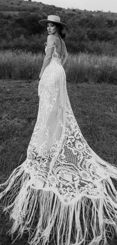 Black and white image of a woman in a lace wedding dress outdoors.