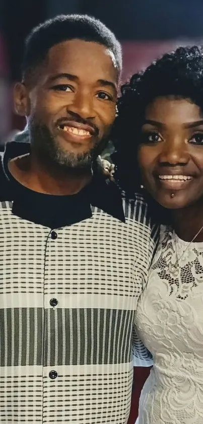 Couple smiling elegantly in black and white attire.