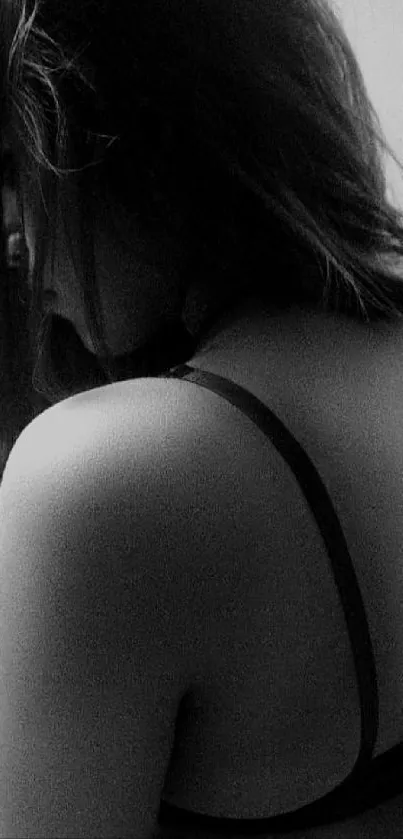 Black and white portrait of a woman's back, conveying elegance and sophistication.