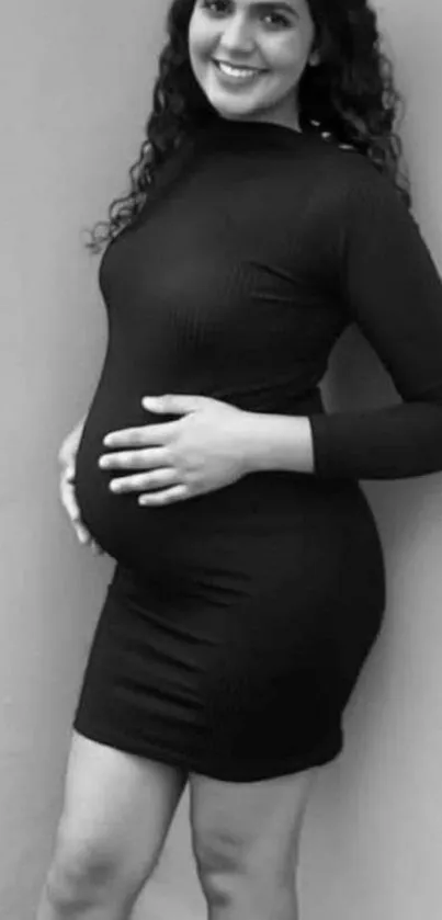 Black and white portrait of a woman in a black dress posing confidently.