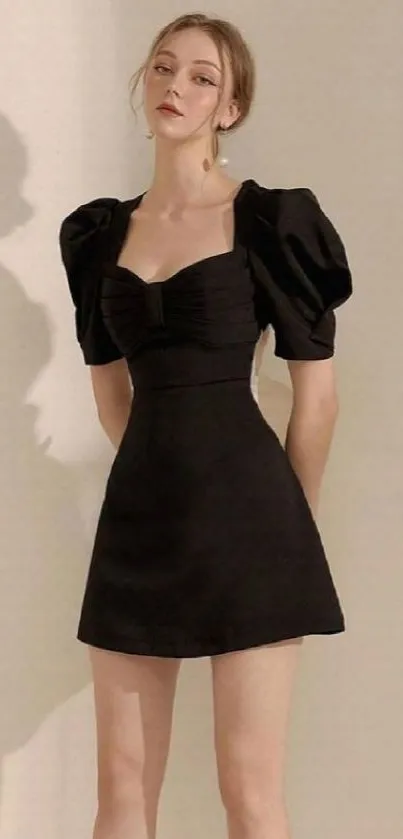 Woman in an elegant black dress against a beige backdrop.