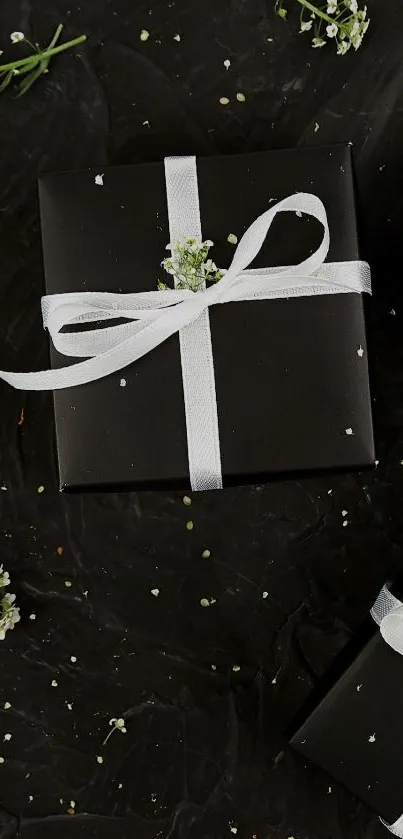 Elegant black gift box with white ribbon on dark background.