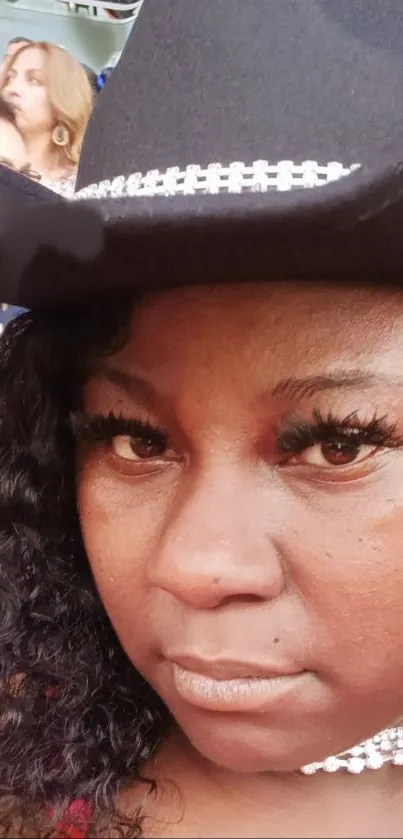 Woman wearing elegant black hat and sparkling jewelry.