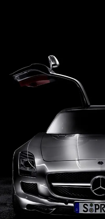 Elegant black sports car with gullwing doors in dramatic lighting.