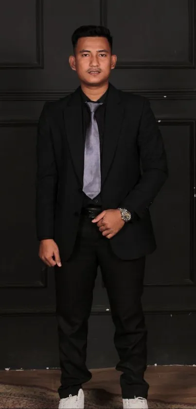 Man in black suit against dark background with stylish look.