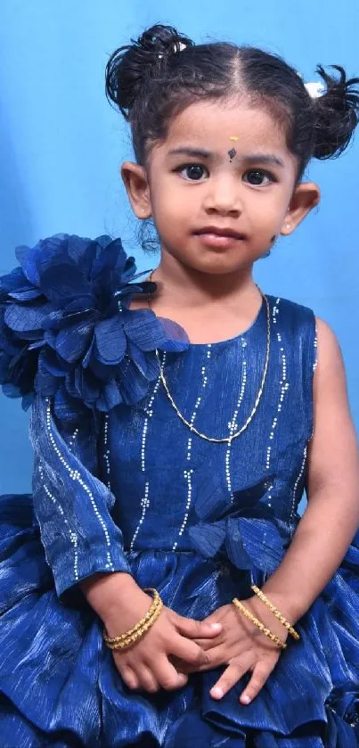 Child in elegant blue dress with floral accents and stylish look.