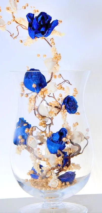 Blue roses in a glass vase with decorative elements.