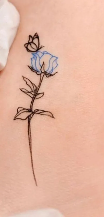 Elegant line art tattoo of a blue flower on skin.