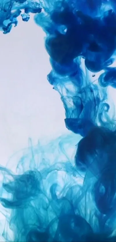 Blue ink swirling in water with a white background, creating abstract art.