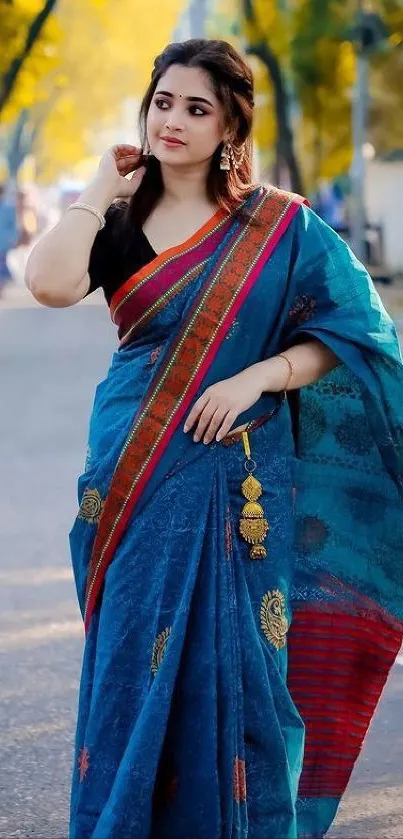 Portrait of a woman in a blue saree with golden accents.