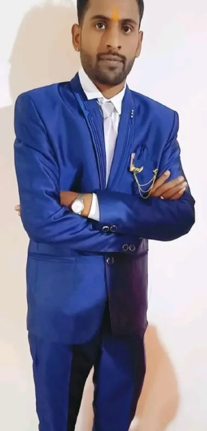 Man in blue suit standing confidently against white background.