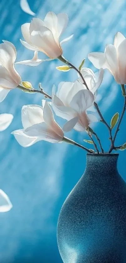 Elegant blue vase with white flowers and petals against a blue background.