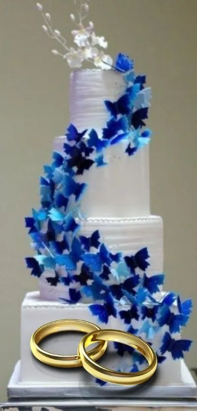 Elegant white wedding cake with blue decoration and gold rings.