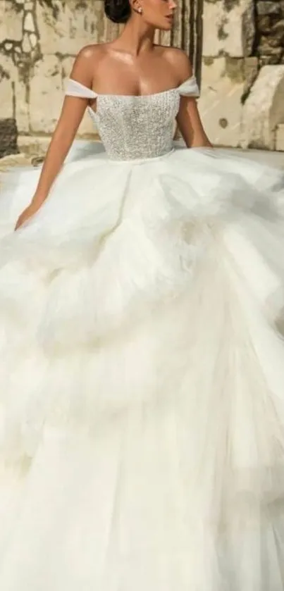 Bride in elegant white gown with ancient stone backdrop.