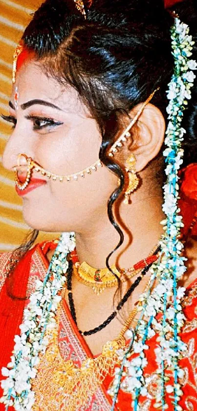 Elegant bride in red and gold attire, showcasing traditional jewelry and flowers.