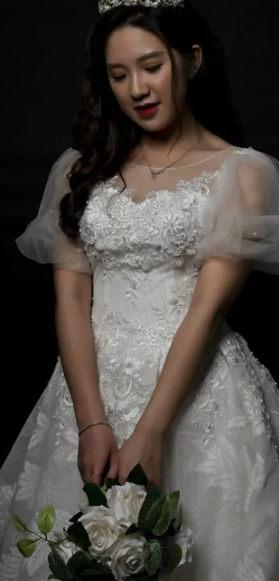 Elegant bride in white gown holding bouquet with dark background.